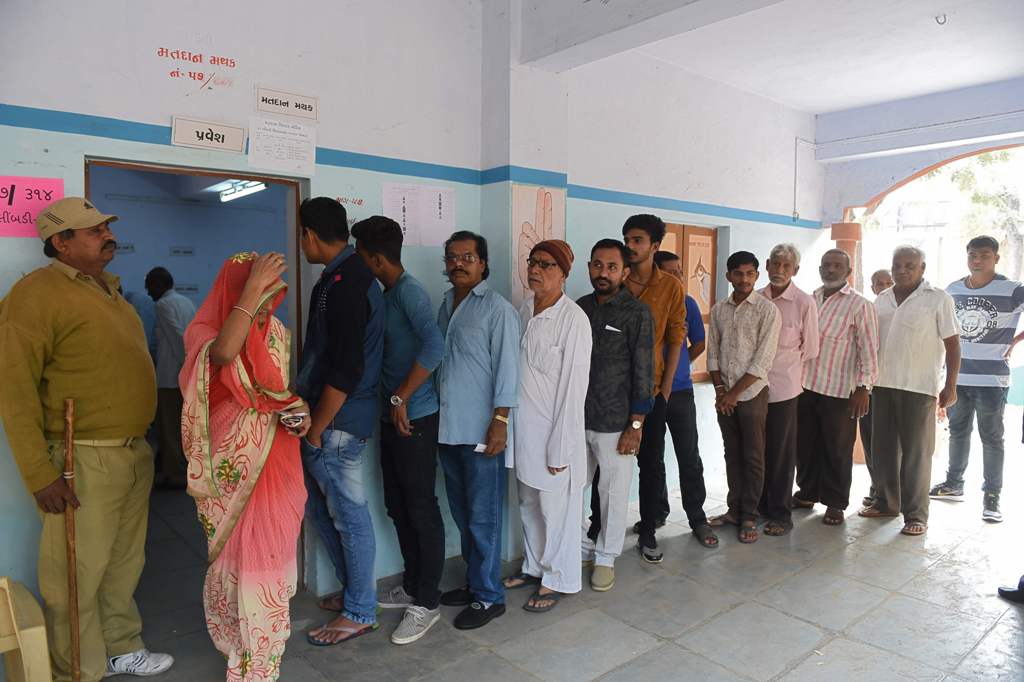 Indian voter queue before casting their ballots during the first phase of Vidhan Sabha elections of Gujarat state in Limbdi, some 100 kms from Ahmedabad on December 9, 2017. / AFP / SAM PANTHAKY