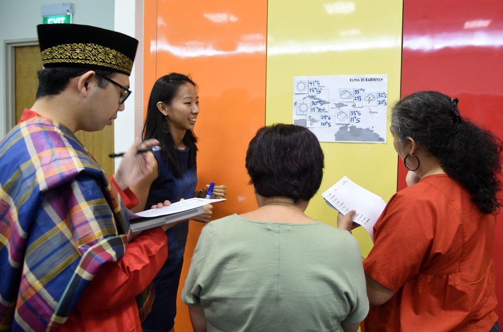 This photograph taken on October 19, 2017 shows students from various cultures in a group discussion during their Kristang language class session at the national library board in Singapore. / AFP.