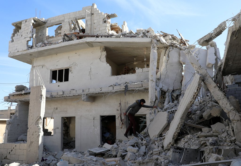 A man is seen on the rubble of damaged buildings in the rebel-held area, in the city of Deraa, Syria December 12, 2017. REUTERS/Alaa al-Faqir.