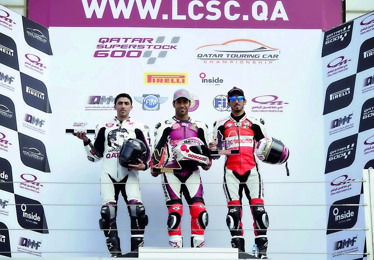 Qatar’s Saeed Al Sulaiti (centre), Nasser Al Malki (left) and Mishal Al Naimi pose for picture on the podium for Race 1 during the opening round of the Qatar Supertsock 600 at Losail International Circuit yesterday.    