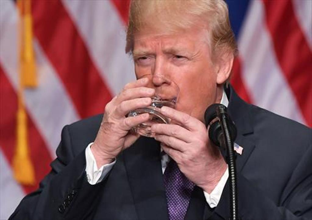 US President Donald Trump takes a sip of water while speaking on his national security strategy at the Ronald Reagan Building in Washington, DC on December 18, 2017. / AFP / MANDEL NGAN