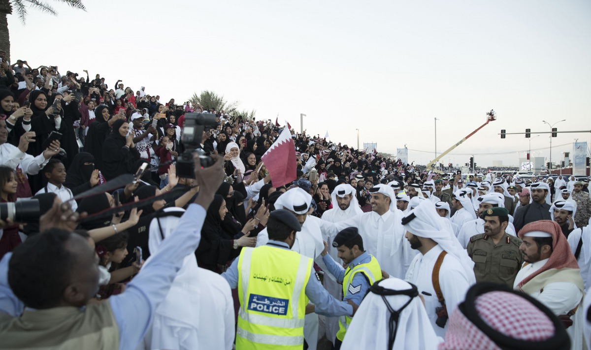 Emir H H Sheikh Tamim bin Hamad Al Thani waving to a huge crowd after attending the Qatar National Day parade on the Corniche, yesterday. 