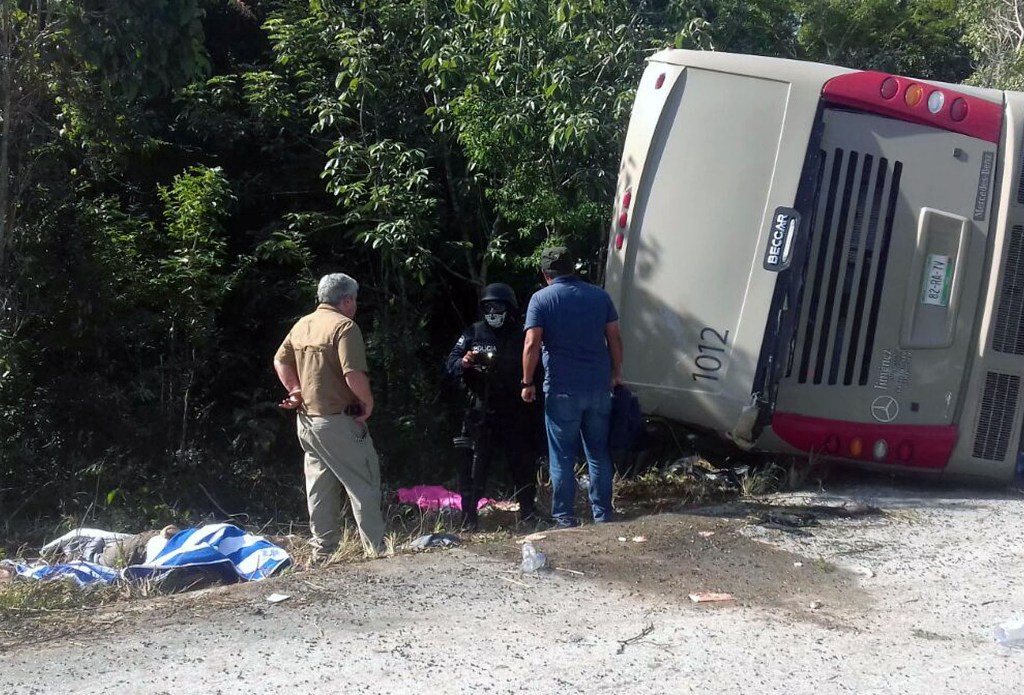 Mexican police officers and paramedics work in the scene of a road accident, where a bus driving tourists to Chacchoben archaeological zone overturned between El Cafetal and Mahahual, in Quintana Roo state, Mexico on December 19, 2017. / AFP.
