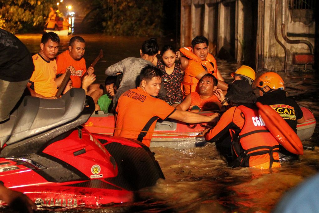 Rescue workers evacuate flood-affected residents in Davao on the southern Philippine island of Mindanao early on December 23, 2017, after Tropical Storm Tembin dumped torrential rains across the island. / AFP / MANMAN DEJETO