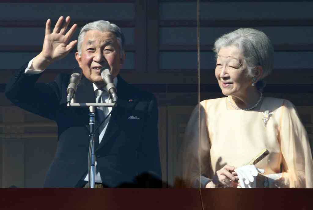 Accompanied by Empress Michiko (R), Japanese Emperor Akihito waves to well-wishers who have gathered to celebrate his 84th birthday, from the balcony at the Imperial Palace in Tokyo on December 23, 2017. / AFP / Toru YAMANAKA