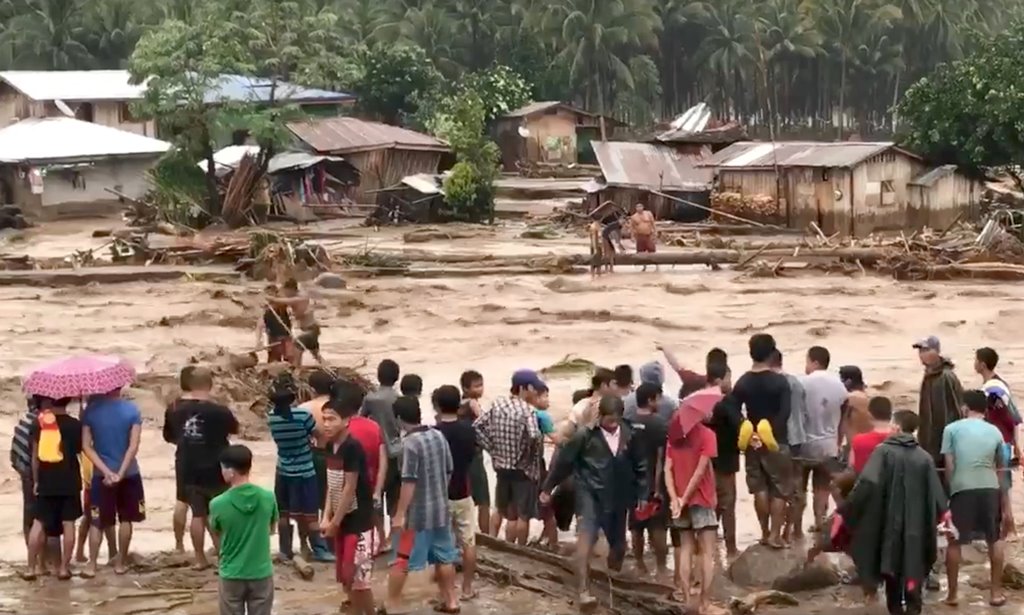 People help to rescue flood victims in Lanao Del Norte, Philippines, December 22, 2017 in this image taken from video footage obtained from social media. Climah Cabugatan Disumala via REUTERS