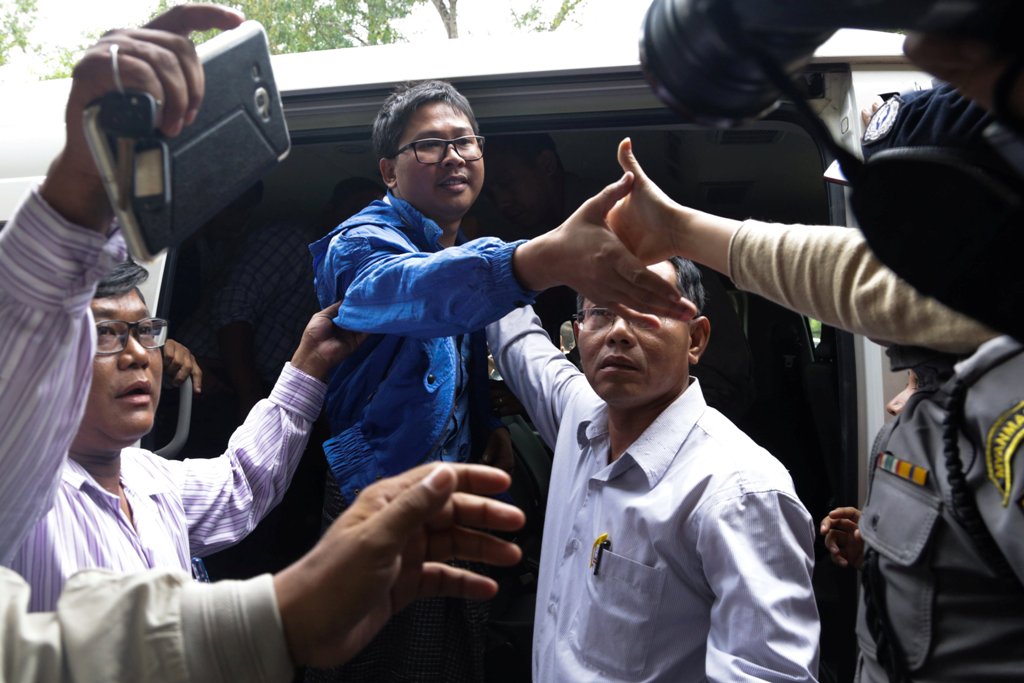 Reuters reporter Wa Lone reaches out to hold the hand of his wife Pan Ei Mon as he arrives at court in Yangon, Myanmar, December 27, 2017. / REUTERS.