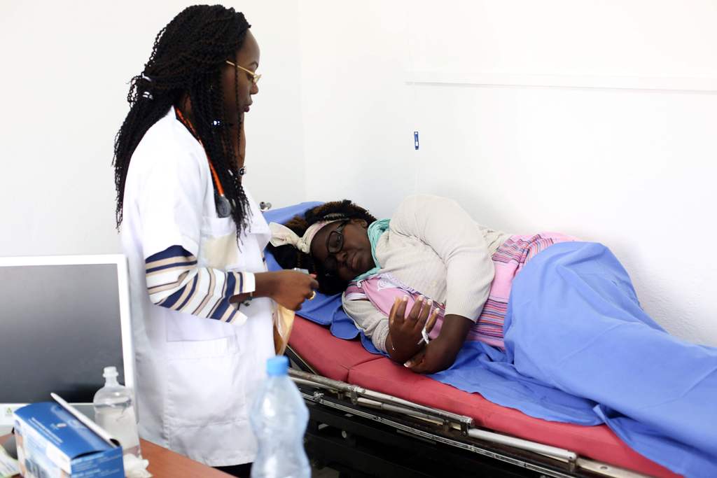 A file photo of a doctor as she treats a patient at the social emergency medical service SAMU's headquarters in Libreville, on December 18, 2017. / AFP / STEVE JORDAN