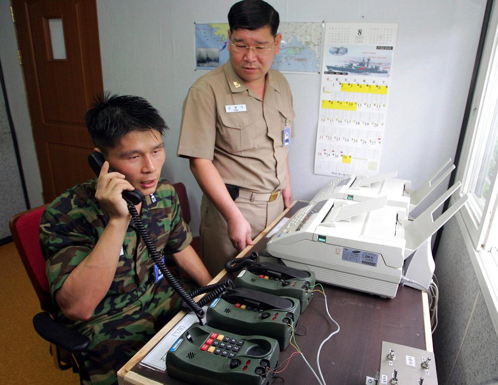 This file photo taken on August 10, 2005 shows South Korean Lieutenant Choi Don-Rim (L) communicating with a North Korean officer during a phone call at a military office near the Demilitarised Zone (DMZ), separating North and South Korea, in Paju, north 