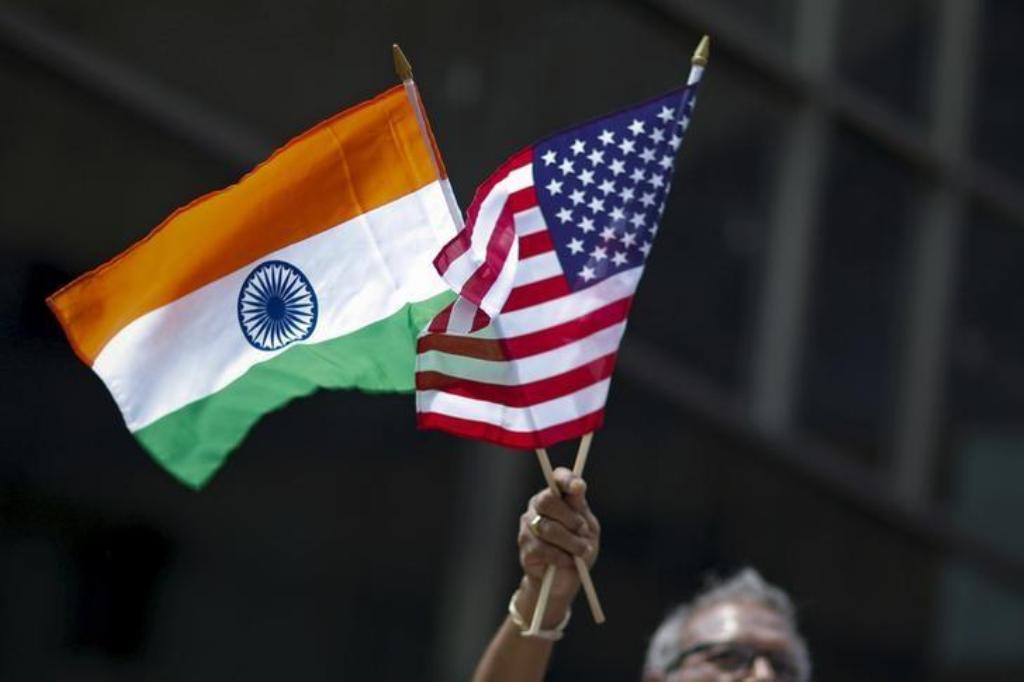 A man holds the flags of India and the US while people take part in the 35th India Day Parade in New York August 16, 2015. REUTERS/Eduardo Munoz/Files