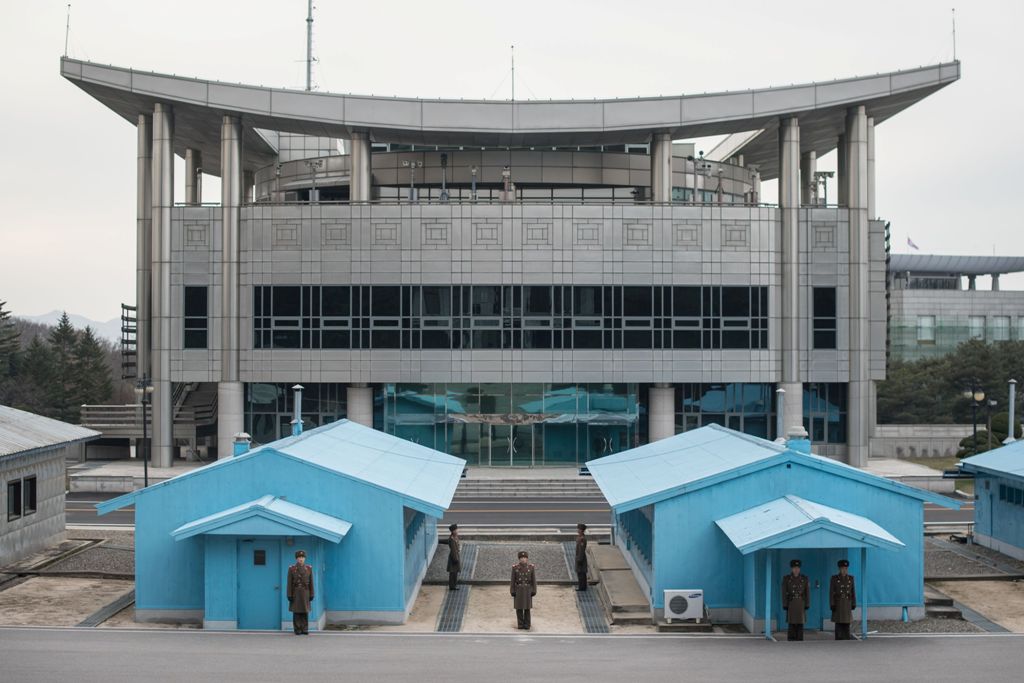 In a photo taken on November 30, 2016 North Korean People's Army (KPA) soldiers stands guard before the military demarcation line and 'Peace House', proposed as the venue of upcoming talks between North and South Korea, at the truce village of Panmunjom i