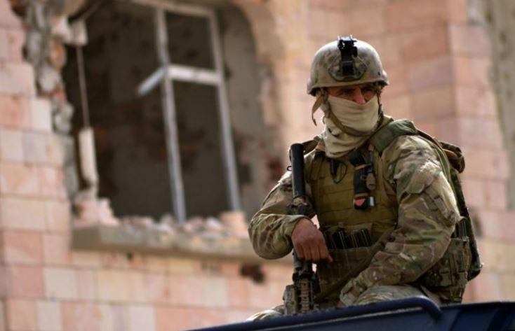 A member of the Tunisian special forces stands guard outside a house containing the body of a man after security forces said they killed a 