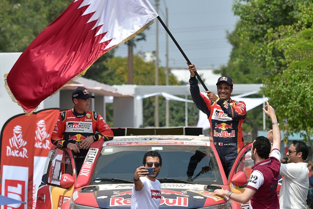 Toyota's Qatari driver Nasser Al-Attiyah (R) and co-driver French pilot Mathieu Baumel are pictured at the podium during the start of the 2018 Dakar Rally, ahead of the rally's Lima-Pisco Stage 1, in Lima on January 6, 2018. AFP / CRIS BOURONCLE
