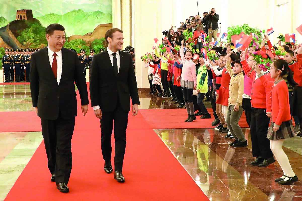 French President Emmanuel Macron (2nd L) walks with Chinese President Xi Jinping as they are greeted by children during a welcome ceremony at the Great Hall of the People in Beijing on January 9, 2018. AFP / Ludovic Marin