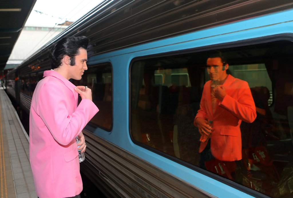 Elvis Presley impersonator Brody Finlay looks at his reflection in a window of the Elvis Express train at Sydney's Central station before it departs for the 26th annual Elvis Festival being held in the New South Wales town of Parkes in Australia, January 