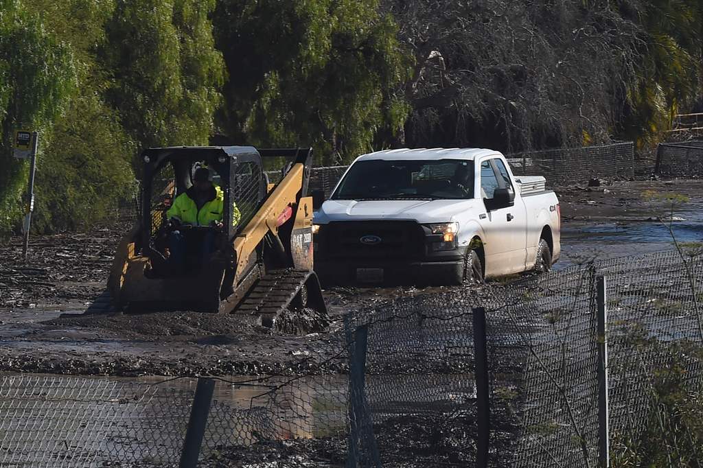 A vehicle is removed from a road along US Highway 101, January 10, 2018 after a massive mudflow in Montecito, California flooded the highway, causing a 30 mile long stretch of the road connecting Los Angeles and San Francisco to be closed. AFP / Robyn Bec