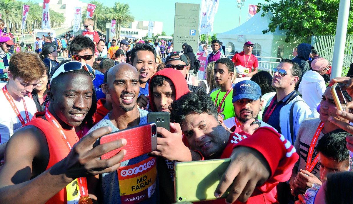 Fans take a selfie with Sir Mo Farah at the Ooredoo Doha Marathon 2018 in Doha yesterday. Right: Children taking part in the special 1 KM fun run pose for a picture.  Pictures: Kammutty VP / The Peninsula