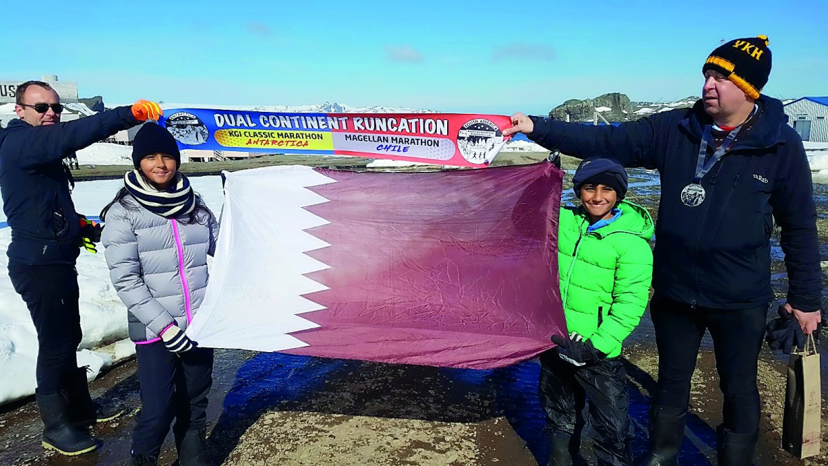 Zara Rahim and Mekaal Rahim, hold the Qatar National Flag after breaking the record for the youngest female, male respectively in the world to complete a full marathon in Antarctica.
