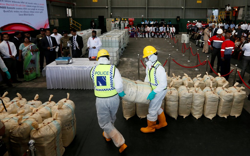 Police officers carry a haul of seized cocaine sack to be destroyed under judicial supervision in Katunayake, Sri Lanka January 15, 2018. Reuters/Dinuka Liyanawatte
