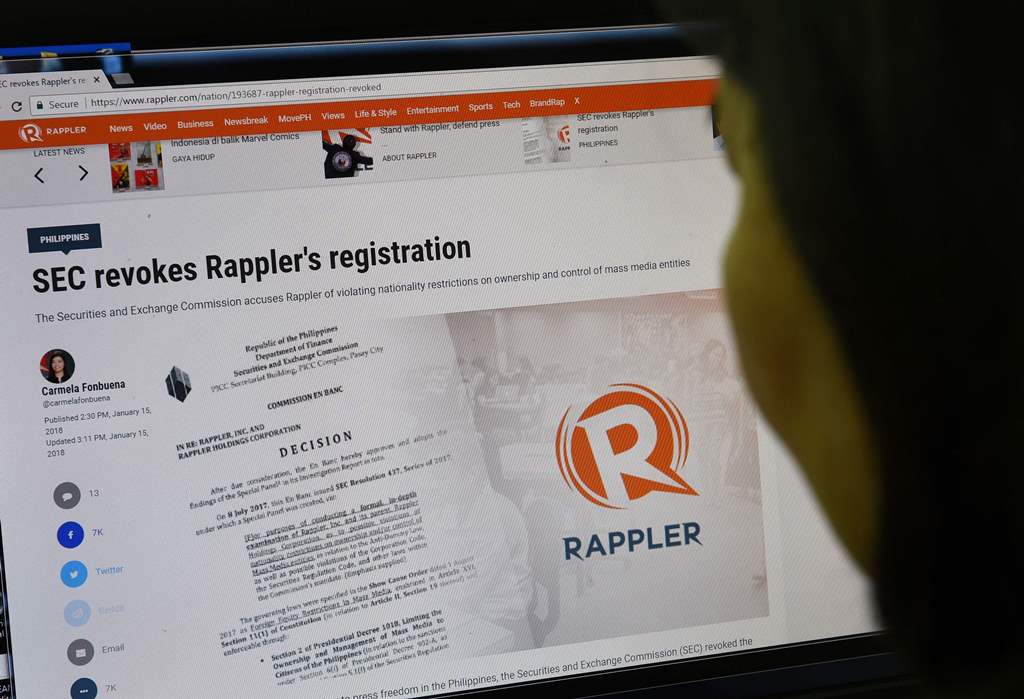 This photo illustration shows a woman reading the website of online news portal Rappler in Manila on January 15, 2018. AFP / TED ALJIBE