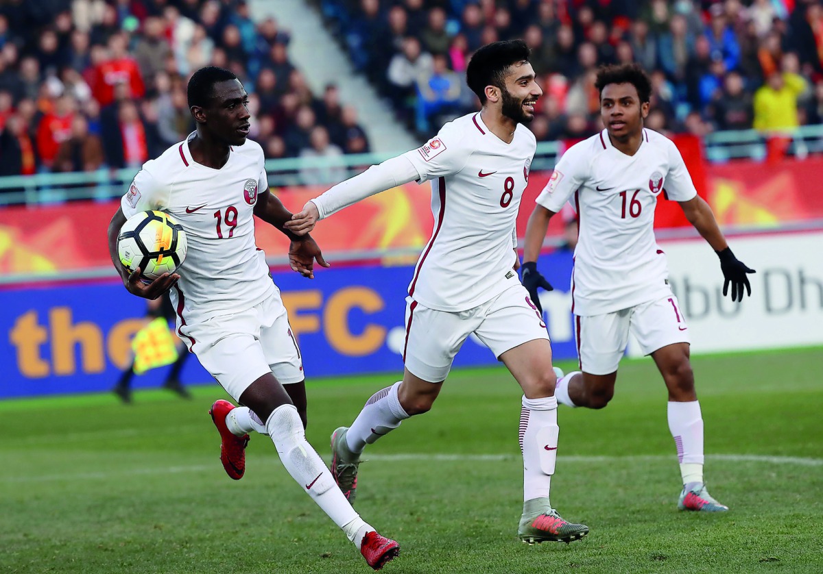 Qatari striker Almoez Ali carries the ball as he celebrates with team-mates  Ahmad Moein (centre) and  Hashim Ali (right) after scoring his first goal against China during their AFC U-23 Asian Cup match played in Changzhou, China on Monday.