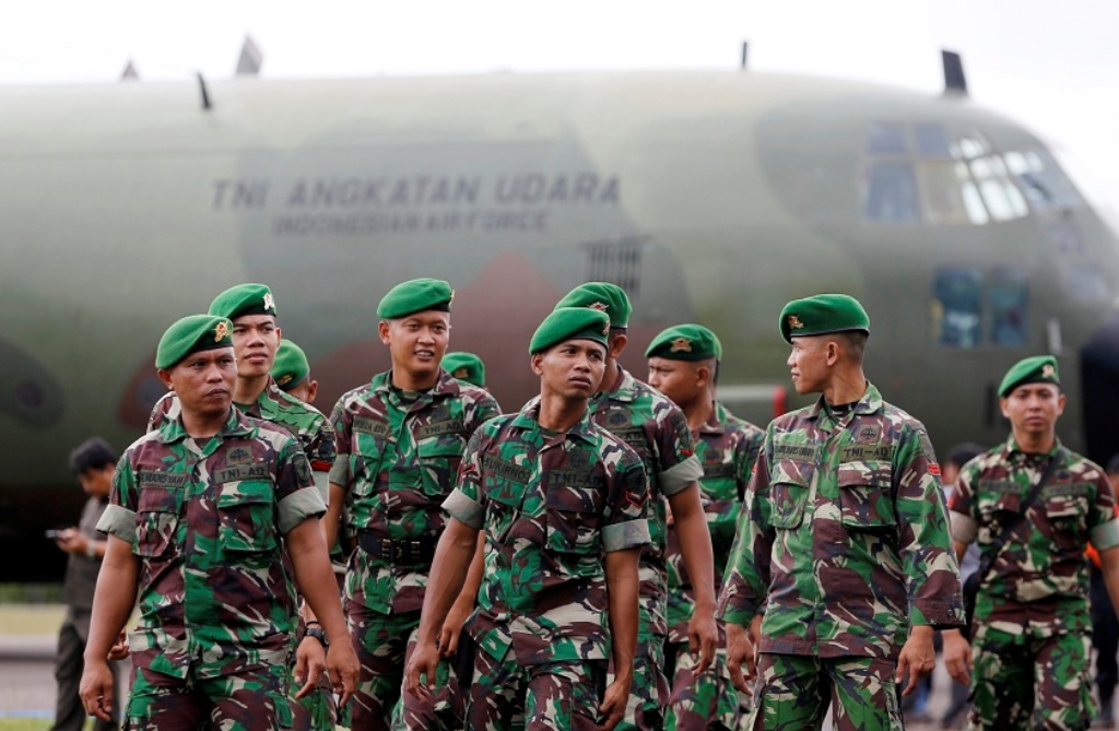 File picture of Indonesia army soldiers walking near a Hercules C-130 in Pangkalan Bun district, December 31, 2014. Indonesia has suspended military cooperation with Australia after offensive training materials were found at an Australian army centre. Reu