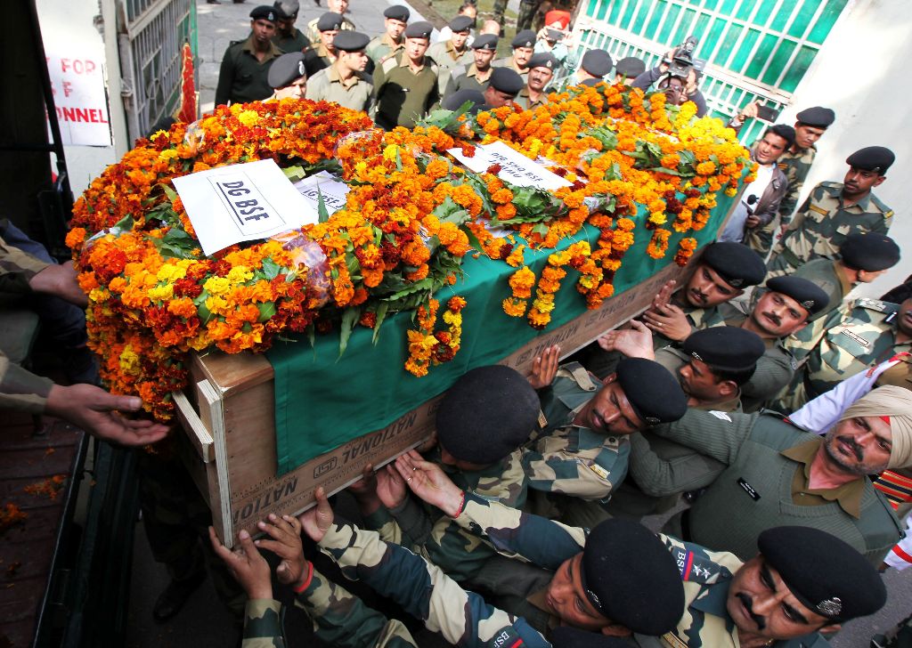 Indian Border Security Force (BSF) officers carry the coffin of slain Head Constable A Suresh during a wreath-laying ceremony at the BSF headquarters in Jammu on January 18, 2018.   AFP