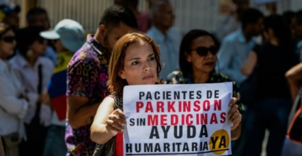 (FILE PHOTO) A woman holds a sign during an anti-government demonstration protesting the shortage of medicines in Caracas, Venezuela on November 20, 2017. AFP