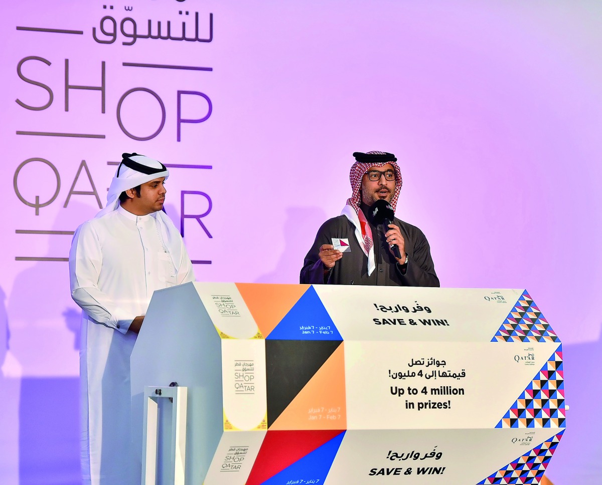 Hamad Al Khaja of QTA (right) announces one of the lucky winners of the second weekly raffle draw held at Hyatt Plaza Mall on Thursday.