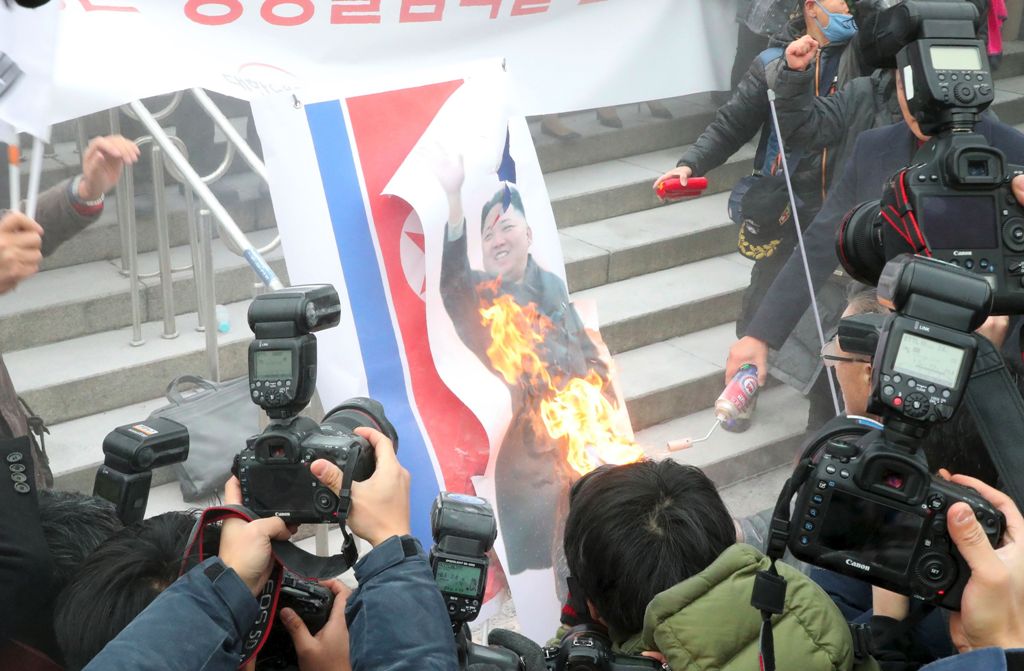 South Korean protestors burn a picture of North Korean leader Kim Jong-Un during an anti-North Korea rally outside Seoul station in Seoul on January 22, 2018 as a North Korean delegation arrives at the station. South Korea OUT / AFP / Dong-A Ilbo / -