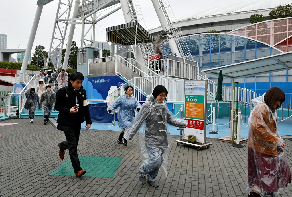 People at a missile evacuation drill at an amusement park near Tokyo Dome stadium in Tokyo, Japan, 22 January 2018. EPA/FRANCK ROBICHON