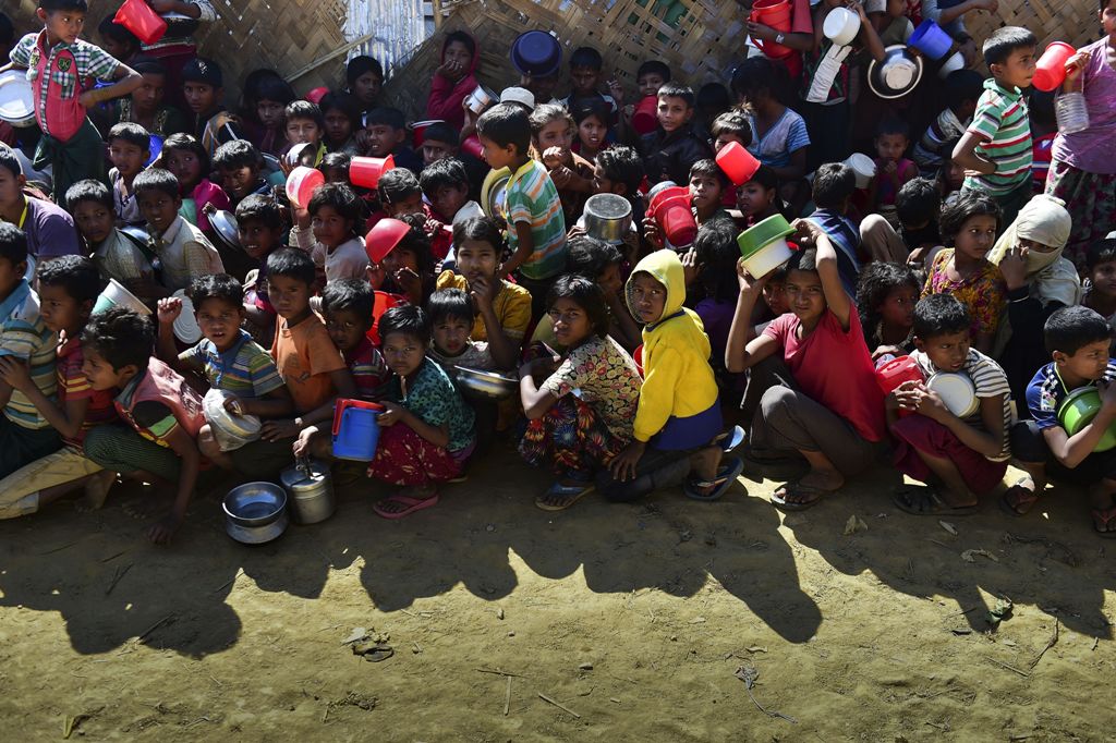 This picture taken on January 21, 2018, shows Rohingya refugees waiting for food aid at Thankhali refugee camp in Bangladesh's Ukhia district. / AFP / MUNIR UZ ZAMAN