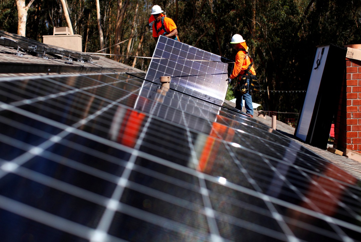 FILE PHOTO: Solar installers from Baker Electric place solar panels on the roof of a residential home in Scripps Ranch, San Diego, California, U.S. October 14, 2016. REUTERS/Mike Blake/File Photo 
