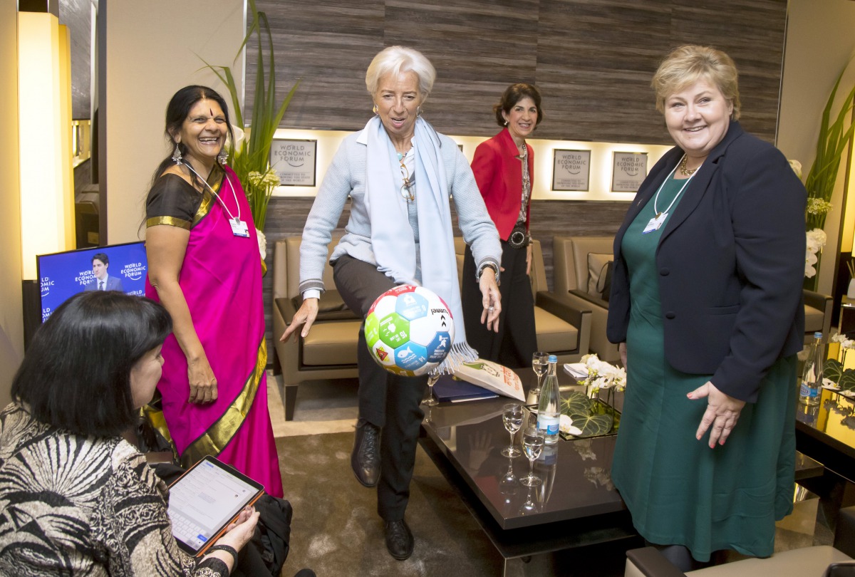 IMF Director Christine Lagarde (C) reacts after kicking a football with the UN sustainability goals given her by the Norwegian Prime Minister Erna Solberg (R), during their meeting at the World Economic Forum (WEF) annual meeting in Davos, Switzerland, 23