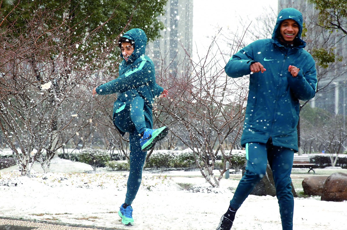 Qatar’s players share light moment in snow on the eve of their third place play-off in Kunshan, China yesterday.