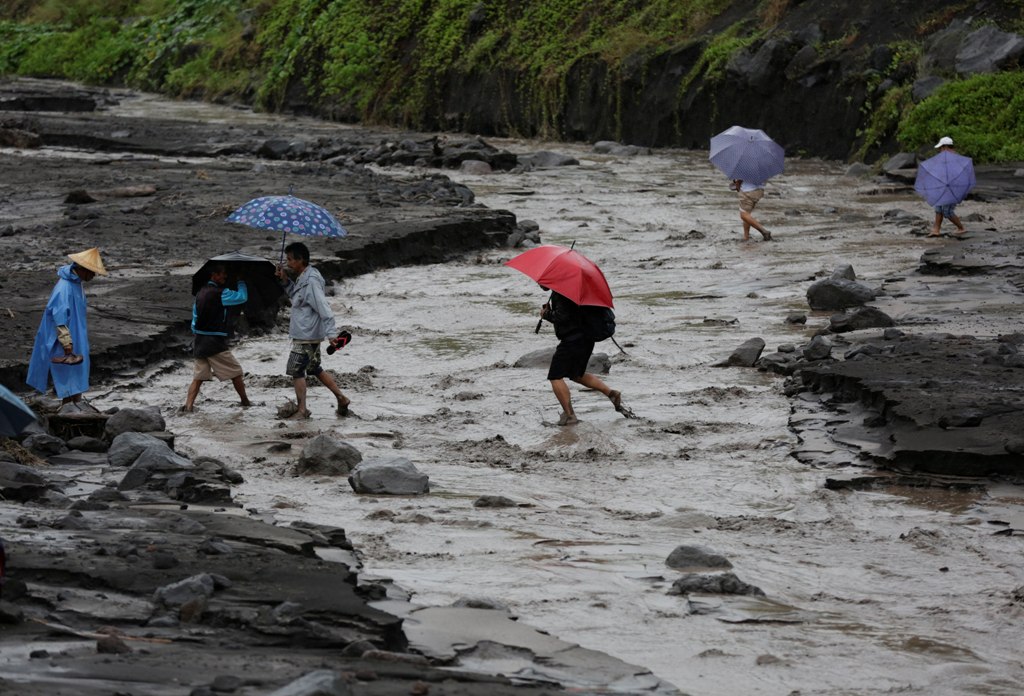 Filipino villagers traverse a river following a flash flood at the slope of the rumbling Mayon Volcano in the town of Daraga, Albay province, Philippines, 27 January 2018. EPA/FRANCIS R. MALASIG