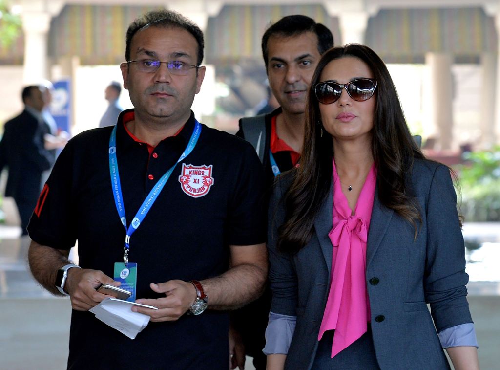 ollywood actor and owner of Kings XI Punjab Team, Preity Zinta (R) and team mentor, Virendra Sehwag arrive for the 2nd day of IPL 2018 Player Auction in Bangalore on January 28, 2018. / AFP / MANJUNATH KIRAN
