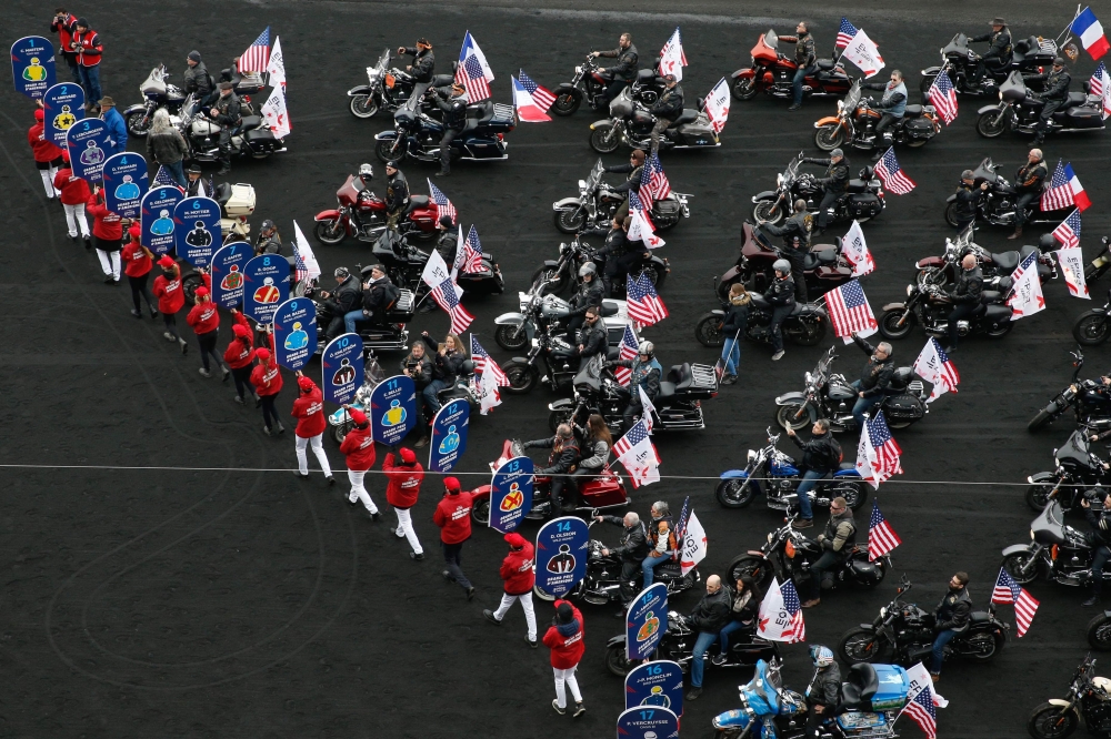 Waving US flags, bikers gets ready to parade on their Harley Davidsons motorbikes prior to the Grand Prix d'Amerique horseracing event on January 28, 2018 at the Vincennes Hippodrome de Paris, in Paris.  AFP / Geoffroy Van Der Hasselt  