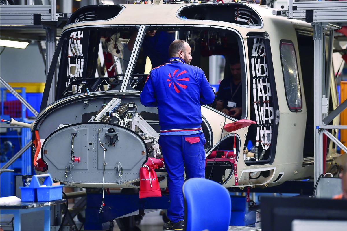 Employees of Leonardo Helicopters company work at a factory on January 30, 2018 in Vergiate, near Milan.  AFP / Marco Bertorello