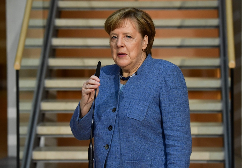 German Chancellor Angela merkel gives a statement as she arrives at the Social Democrats Party (SPD) headquarters on February 4, 2018 in Berlin. / AFP / Tobias SCHWARZ

