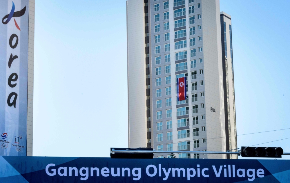 A photograph taken on February 5, 2018, shows the North Korean national flag displayed outside their dormitory across three stories at the athletes' village in Gangneung, ahead of the Pyeongchang 2018 Winter Olympic Games.  AFP / MLADEN ANTONOV