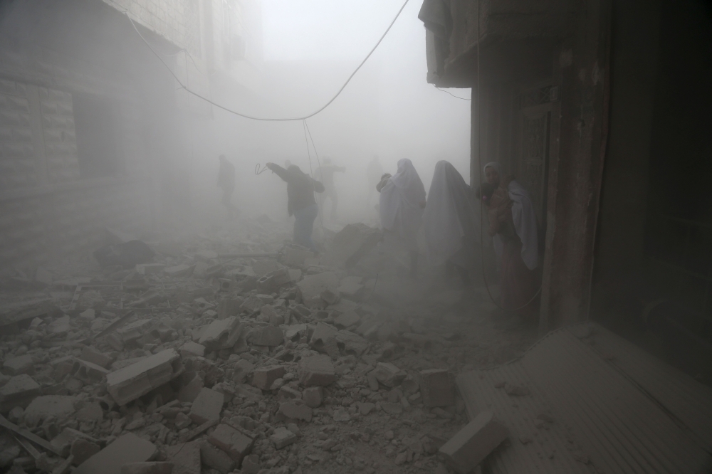Syrian flee their homes following an airstrike in the rebel-held besieged town of Arbin, in the eastern Ghouta region on the outskirts of the capital Damascus on February 2, 2018. / AFP / ABDULMONAM EASSA