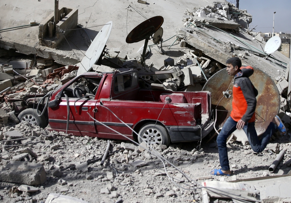 A man is seen running after an air raid in the besieged town of Douma in eastern Ghouta in Damascus, Syria, February 6, 2018. Reuters/ Bassam Khabieh