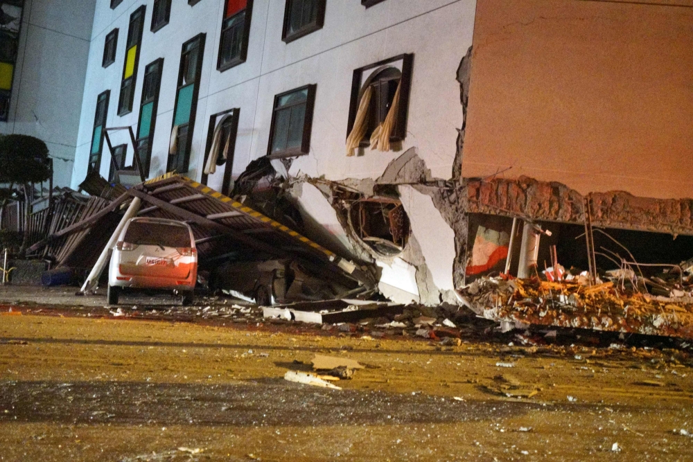 A damaged vehicle stands in rubble outside the Marshal Hotel in Hualien, eastern Taiwan early February 7, 2018, after a strong earthquake struck the island. AFP / Paul Yang