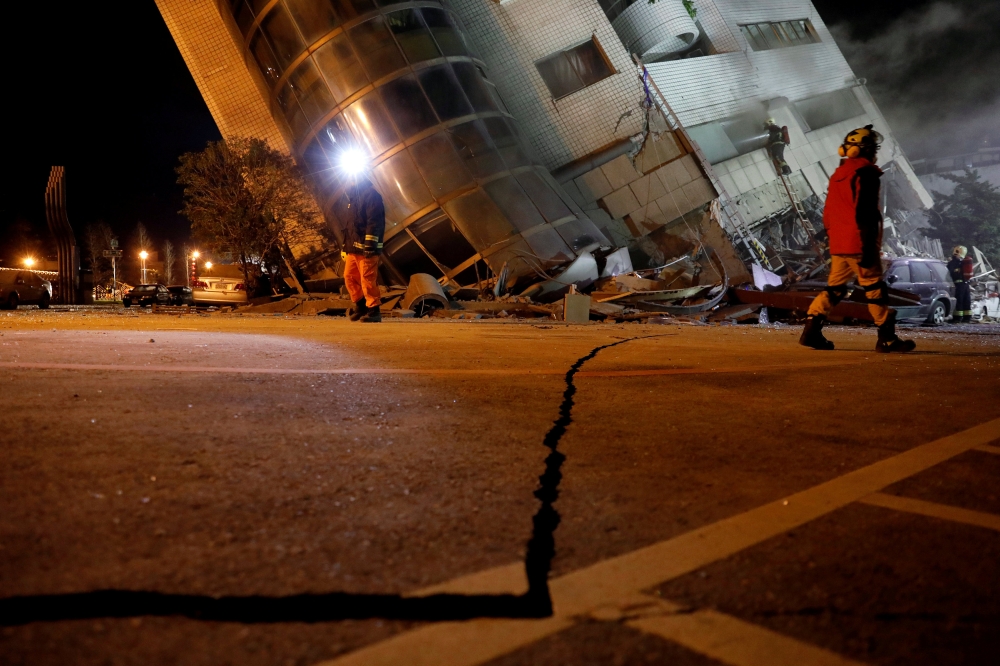 Rescue personnel search a collapsed building after an earthquake hit Hualien, Taiwan February 7, 2018. REUTERS/Tyrone Siu 