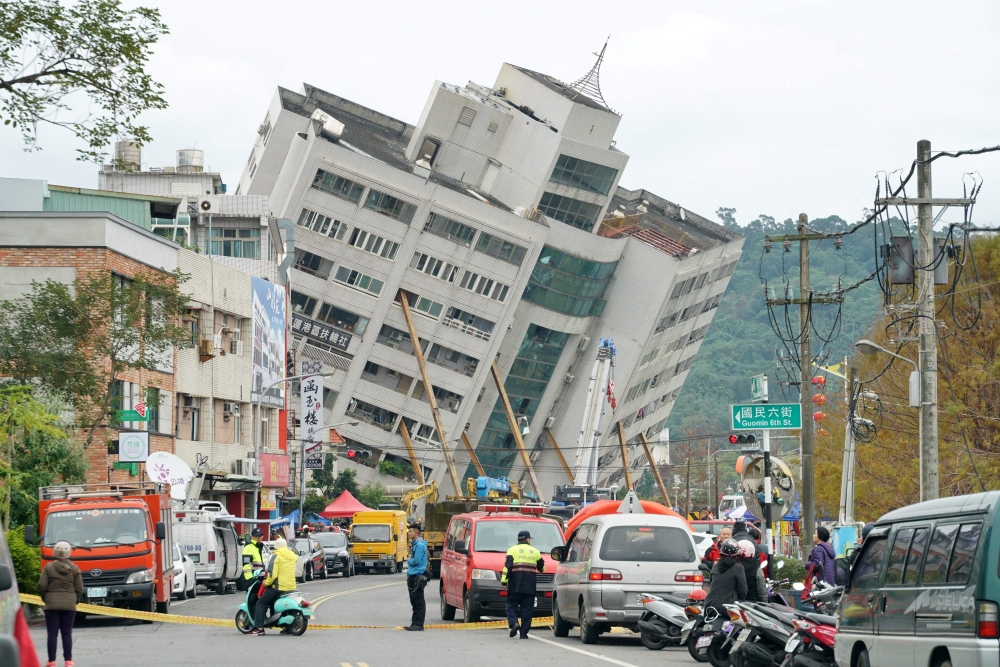 Rescue and emergency workers block off a street where a building came off its foundation, the morning after a 6.4 magnitude quake hit the eastern Taiwanese city of Hualien, on February 7, 2018. AFP / PAUL YANG