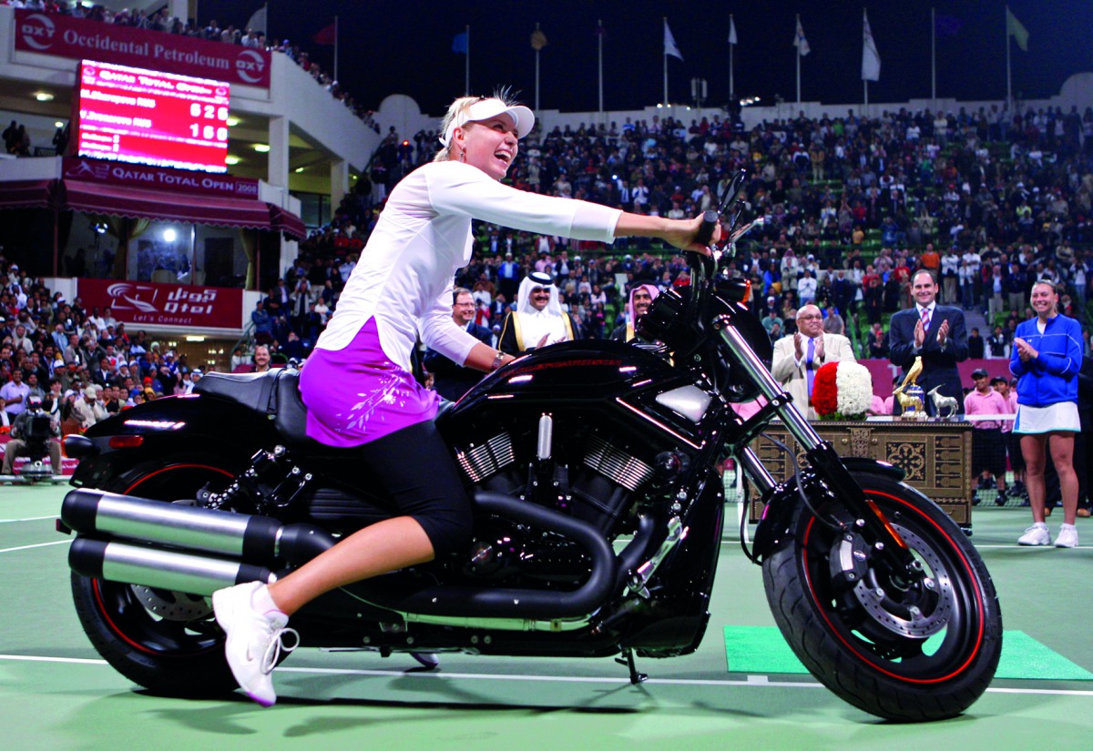 Russia’s Maria Sharapova sits on a motorcycle after defeating compatriot Vera Zvonareva in the final of the Qatar Open tournament in Doha in this 2008 file picture.