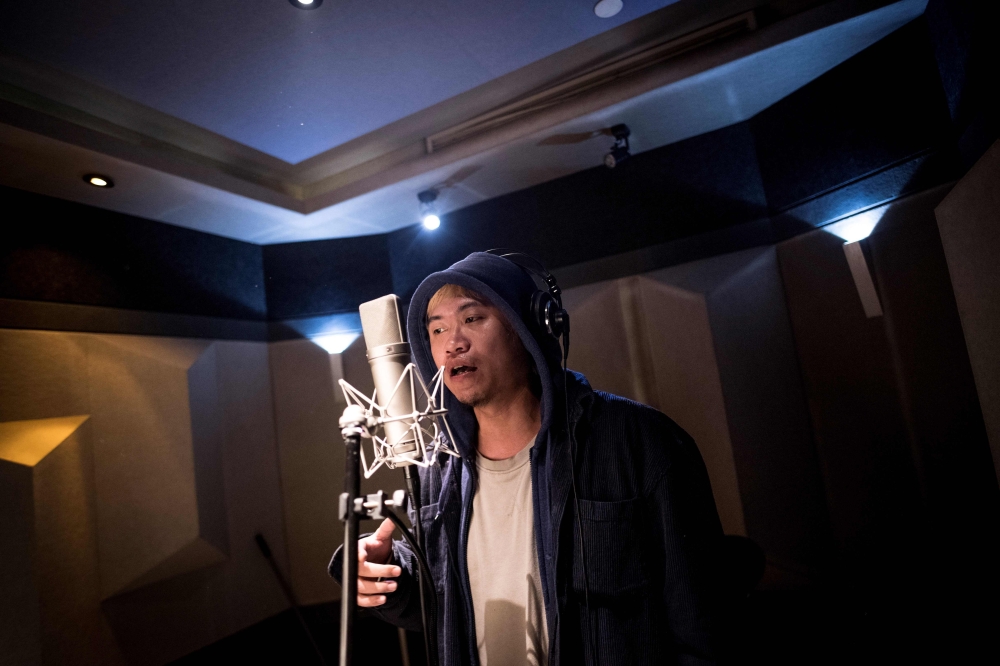 This picture taken on February 5, 2018 shows Shanghai rapper Naggy singing in his studio in Shanghai. AFP / Johannes Eisele 