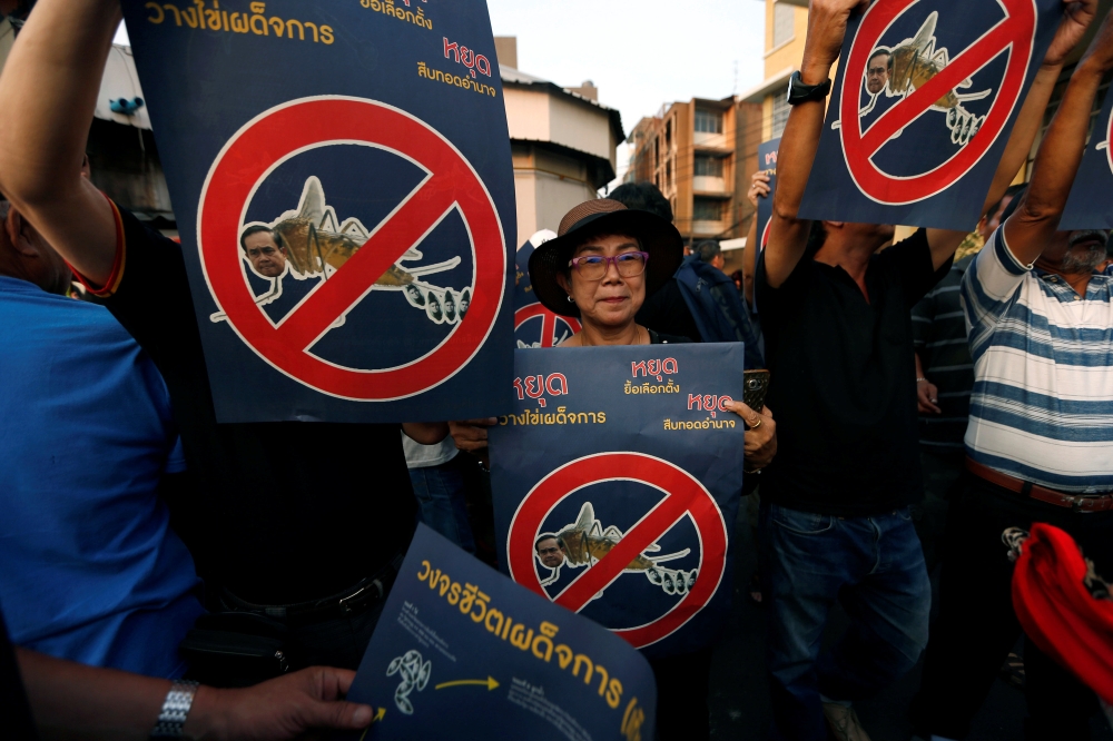 Pro-democracy activists hold up placards during protest against junta near Democracy Monument in Bangkok, Thailand, February 10, 2018. Reuters/Soe Zeya Tun	