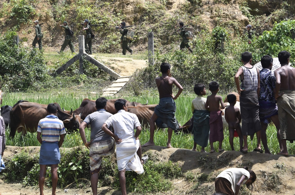 Rohingya Muslim refugees in Jalpatoli refugee camp, in the no-man's land area between Myanmar and Bangladesh, watch as Myanmar soldiers patrol on the other side of the border, near Gumdhum village in Ukhia. AFP / DOMINIQUE FAGET / XGTY